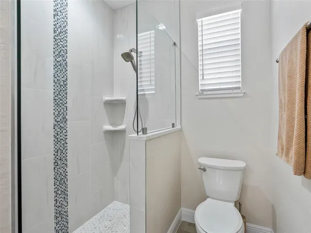 a bedroom with a bed and a lamp on dresser