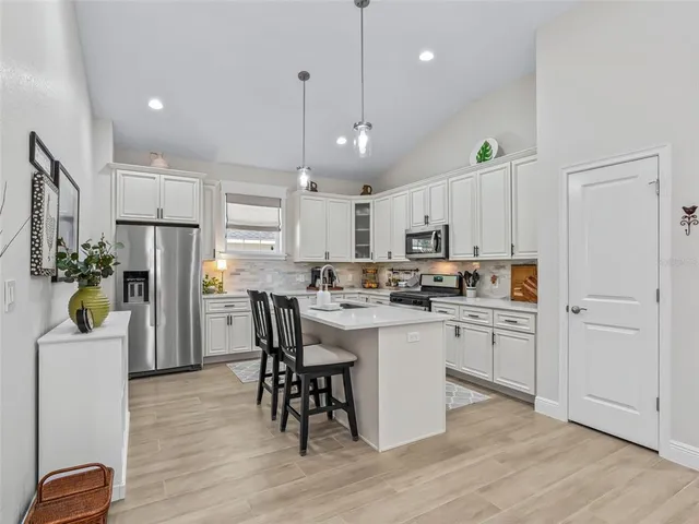 a kitchen that has a lot of cabinets a sink and appliances in it