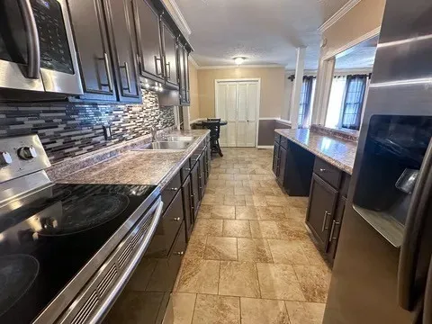 a kitchen with stainless steel appliances granite countertop a stove a sink and a microwave