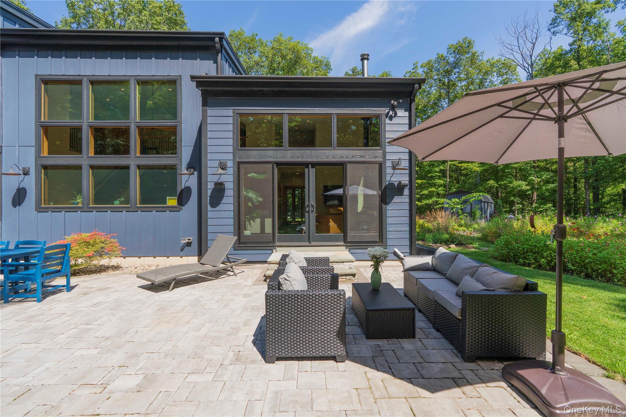 105 Iron Mountain Road Warwick, NY 10990 - Photo 8 of 49 a view of a patio with couches table and chairs under an umbrella