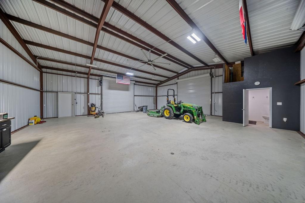 1161 Alsdorf Road Ennis, TX 75119 - Photo 22 of 28 Spacious metal construction building featuring a high-pitched roof, exposed support beams, and a concrete floor