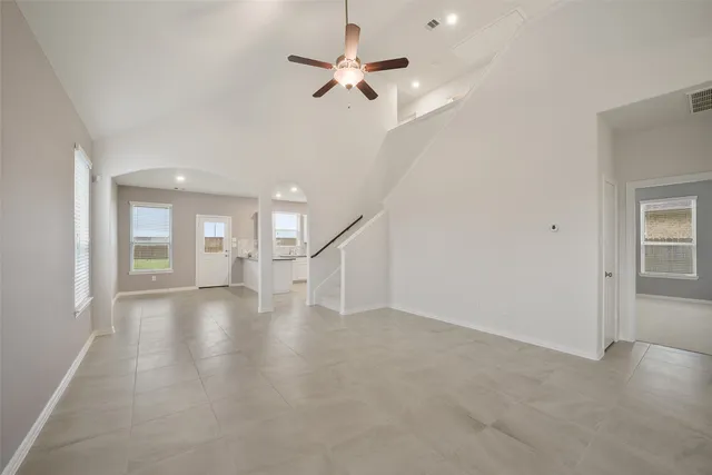 a view of an empty room with a ceiling fan and window