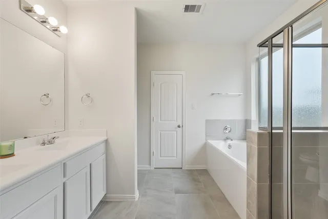 a bathroom with a tub sink a mirror and a shower
