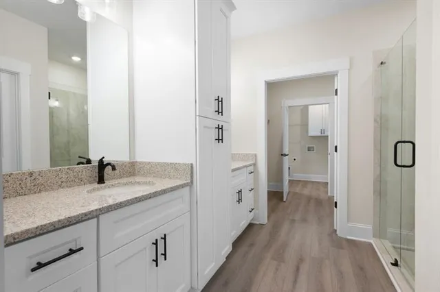 a en suite bathroom with a granite countertop sink mirror and shower
