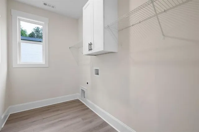 a view of small space with wooden floor and a window