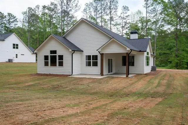 a view of a house with backyard and trees