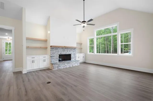 a view of empty room with wooden floor and fireplace