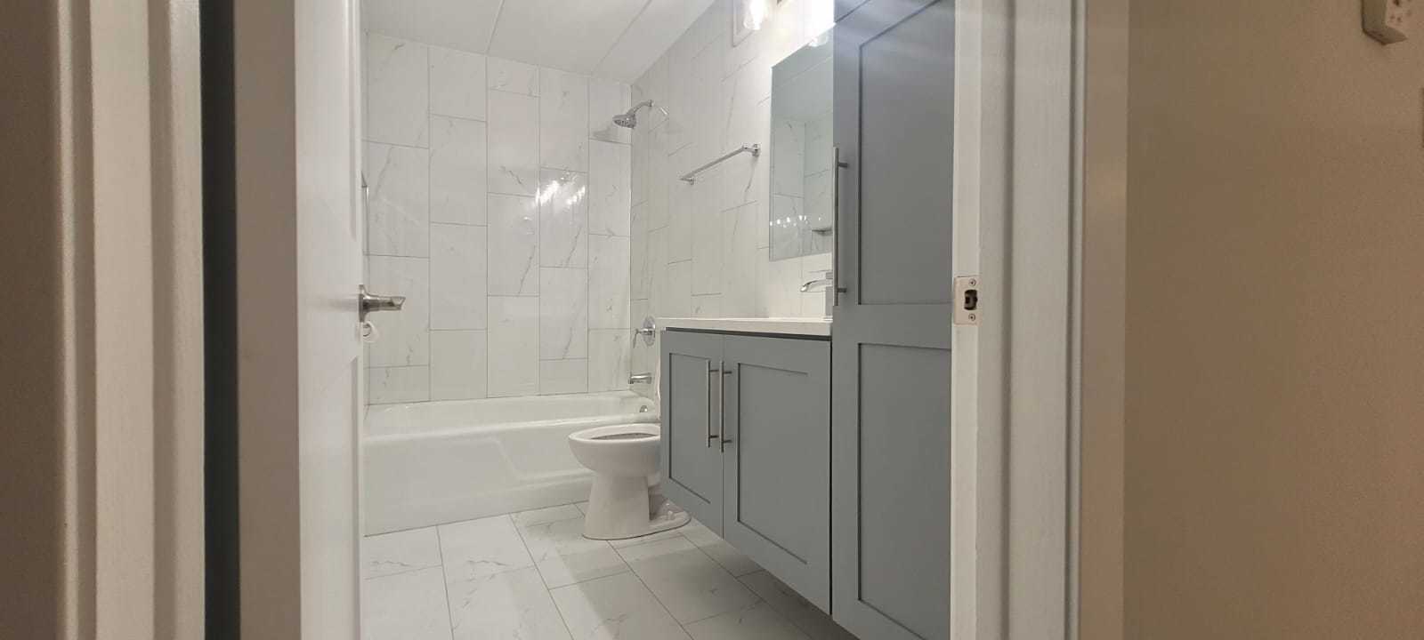 11024 Kilpatrick Avenue, Unit 3 Oak Lawn, IL 60453 - Photo 6 of 9 a bathroom with a granite countertop toilet a sink and bathtub