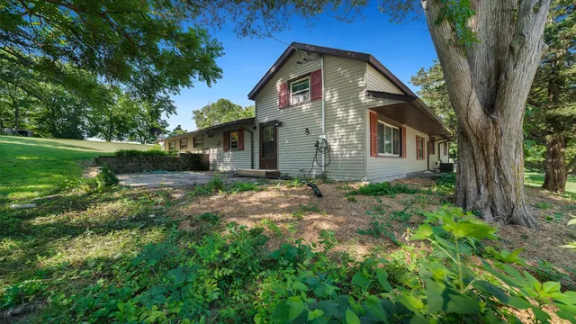 a view of a swimming pool with a yard and trees in the background
