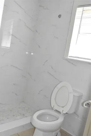 a bathroom with a toilet a sink and a window