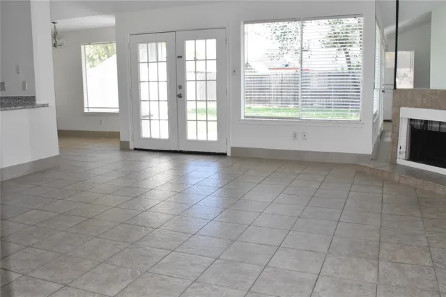 a view of an empty room with a fireplace and a window