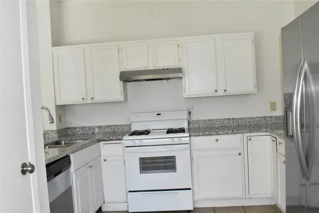 a kitchen with white cabinets and white appliances