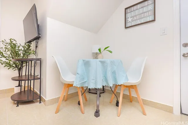 a view of a dining room with furniture and a potted plant