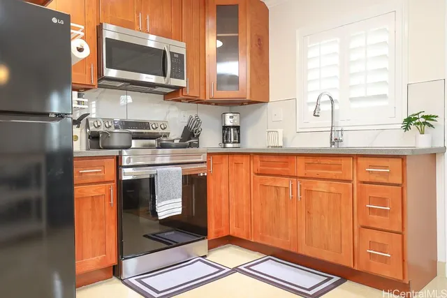 a kitchen with stainless steel appliances granite countertop a stove a sink and a microwave