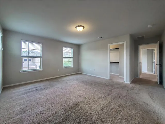 an empty room with windows and closet