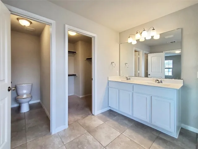 a spacious bathroom with a double vanity sink mirror and toilet