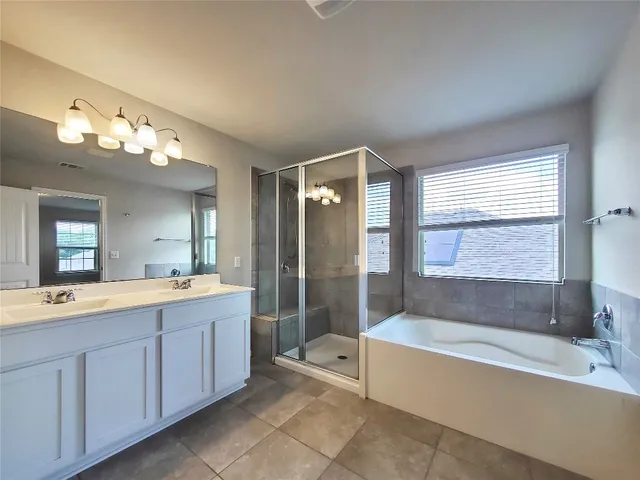 a large spacious bathroom with a large tub shower and sink