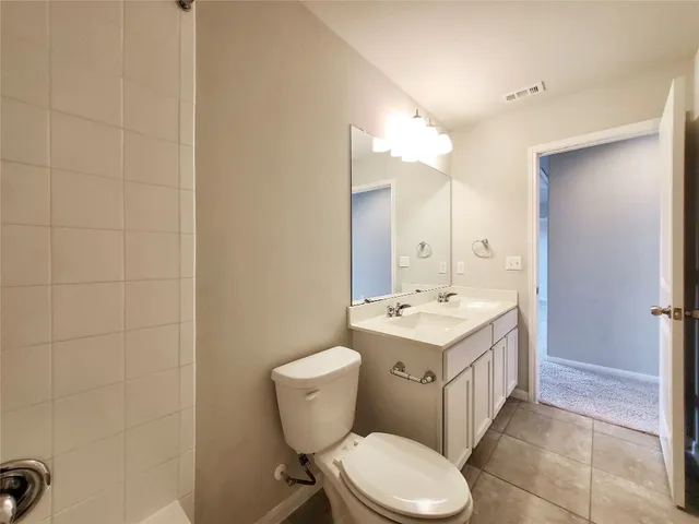 a bathroom with a toilet sink vanity and mirror