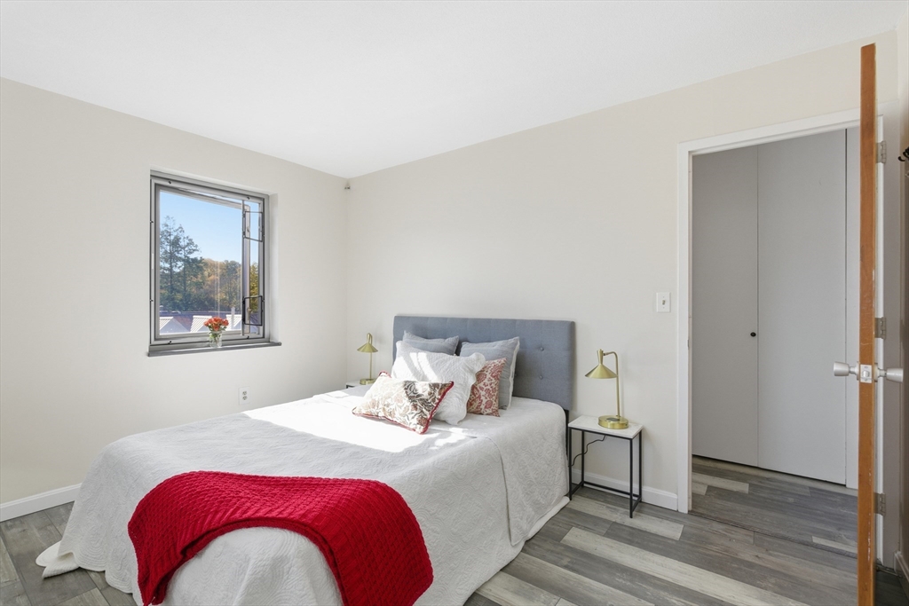 125 Trapelo Road, Unit 21 Belmont, MA 02478 - Photo 12 of 19 a bedroom with a bed and wooden floor