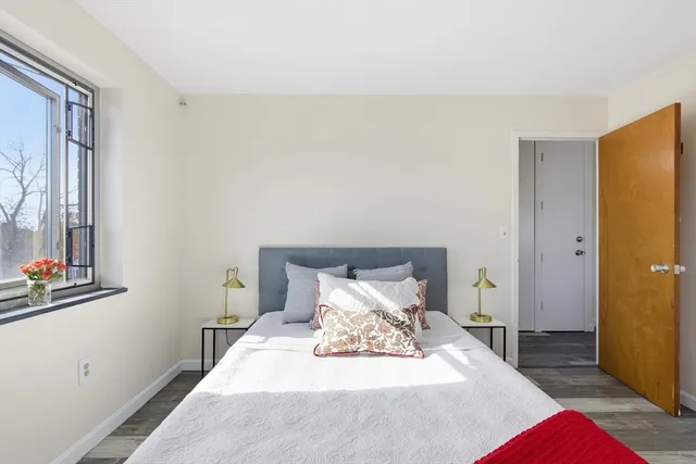 a bedroom with a bed and wooden floor