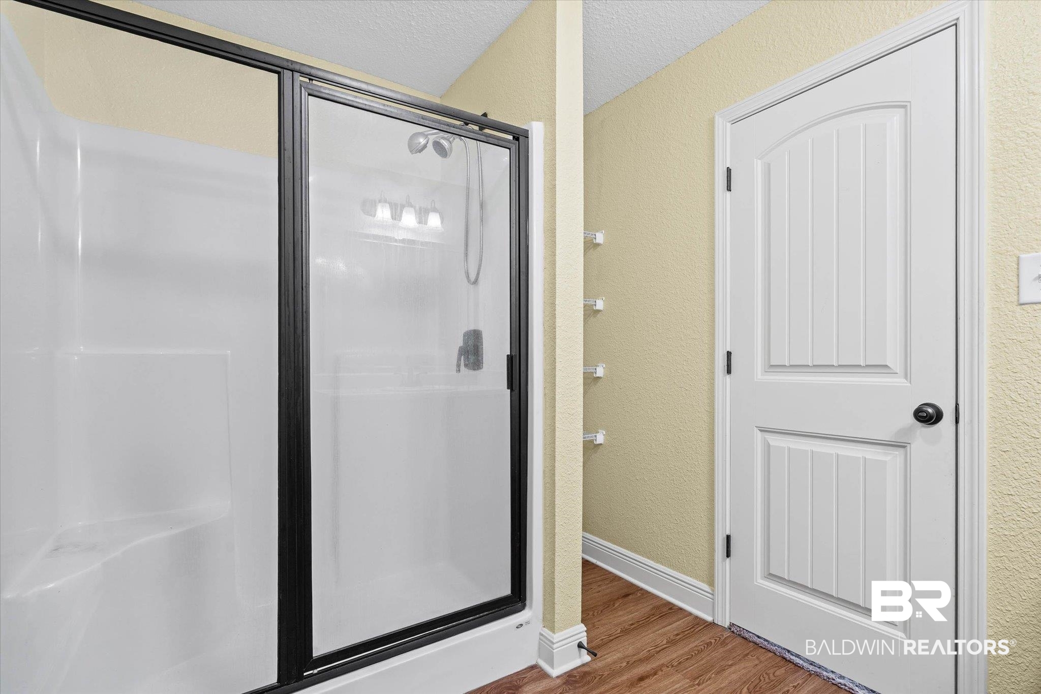 101 Washington Boulevard Foley, AL 36535 - Photo 16 of 32 Full bath featuring a shower stall, a textured wall, wood finished floors, and a textured ceiling