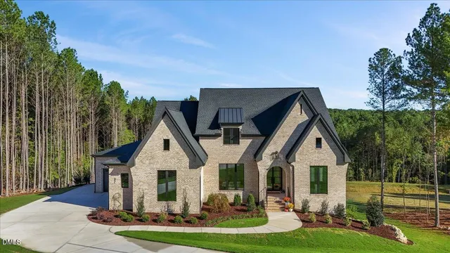 a view of a house with a yard and potted plants