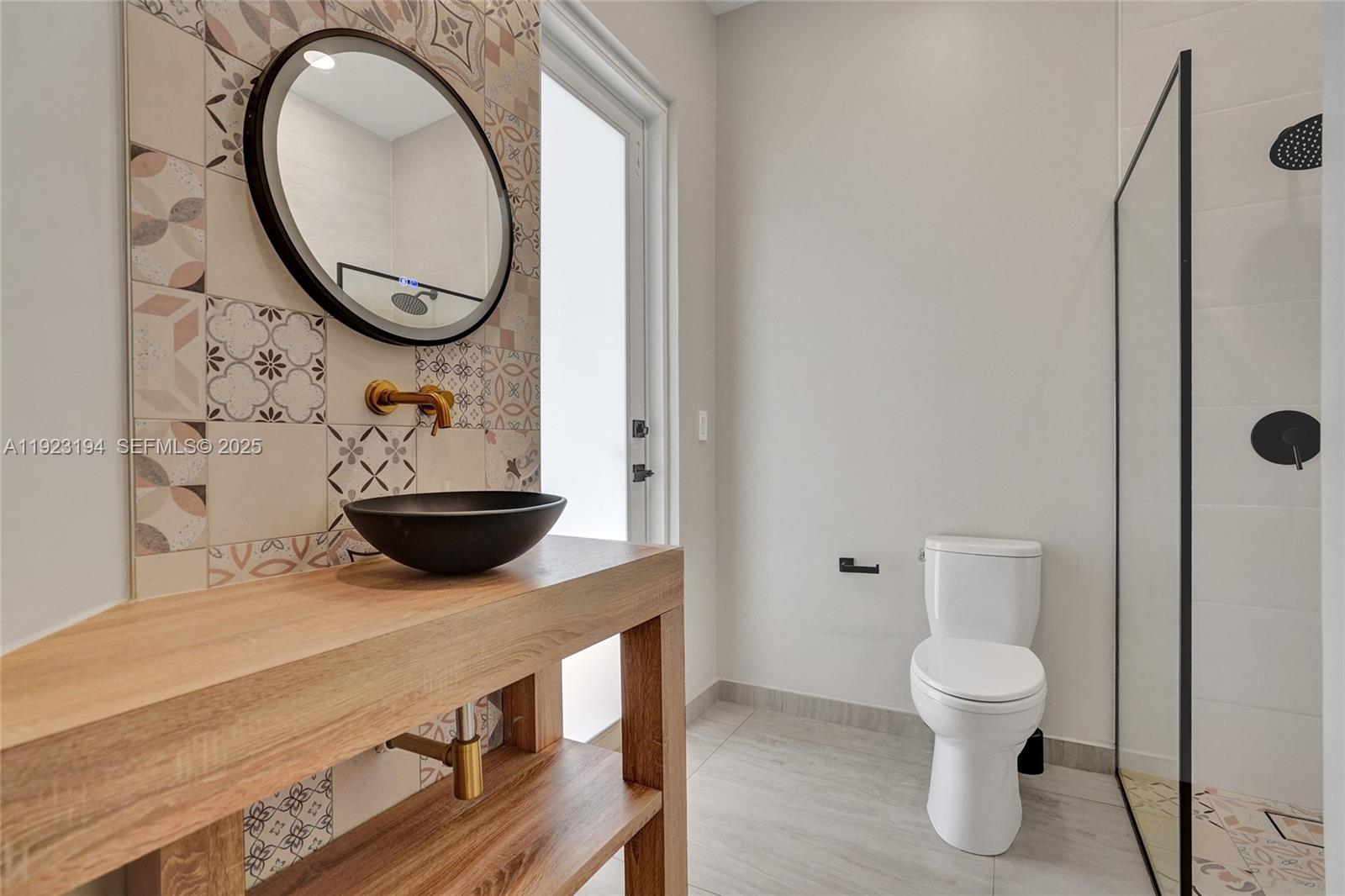 3757 Northeast 208th Terrace Aventura, FL 33180 - Photo 23 of 74 a bathroom with a toilet a sink and a mirror