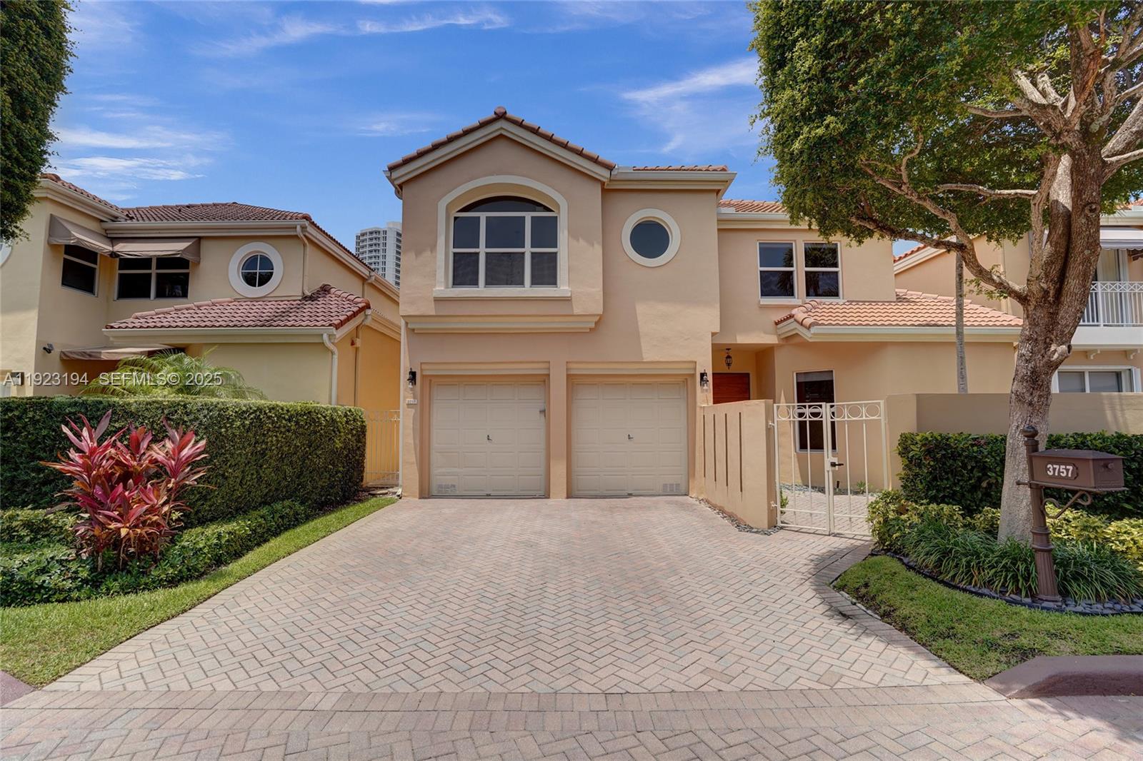 3757 Northeast 208th Terrace Aventura, FL 33180 - Photo 3 of 74 a front view of a house with garden