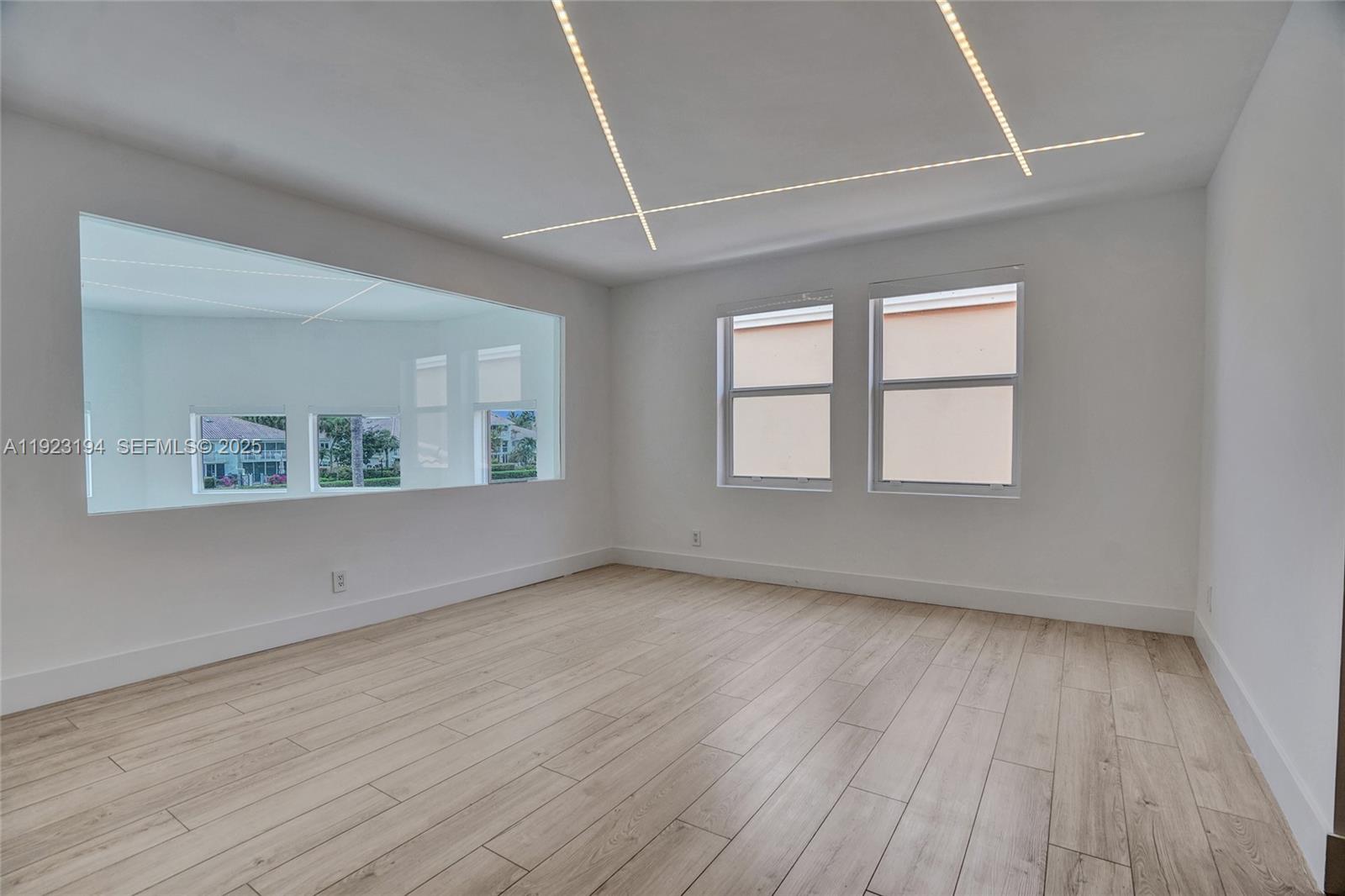 3757 Northeast 208th Terrace Aventura, FL 33180 - Photo 35 of 74 an empty room with wooden floor and windows