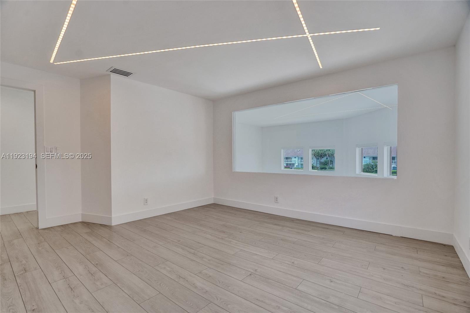 3757 Northeast 208th Terrace Aventura, FL 33180 - Photo 36 of 74 a view of an empty room with wooden floor and a window