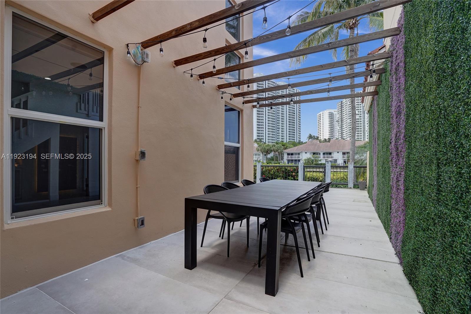 3757 Northeast 208th Terrace Aventura, FL 33180 - Photo 51 of 74 a patio with a table and chairs
