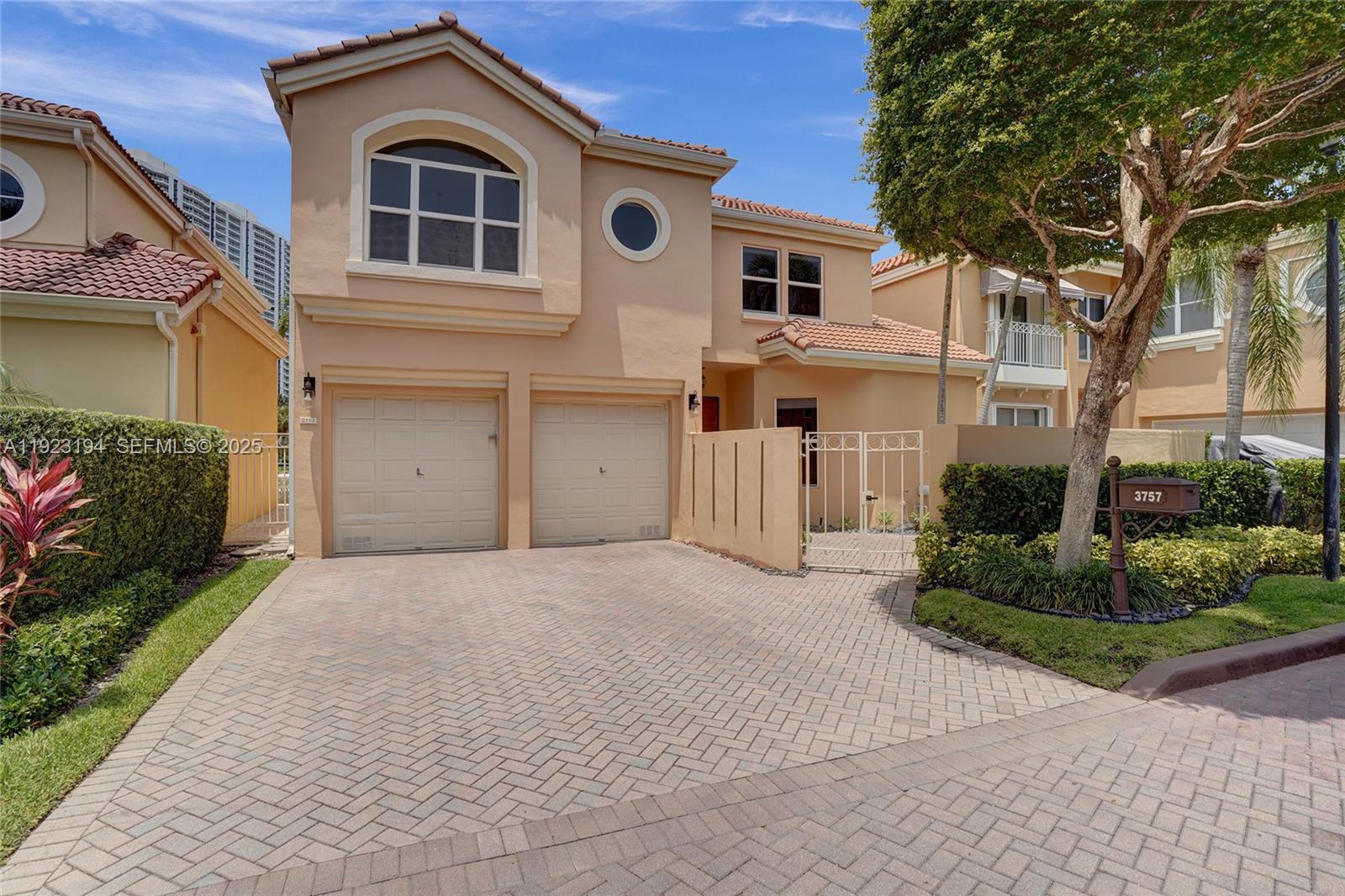 3757 Northeast 208th Terrace Aventura, FL 33180 - Photo 57 of 74 a front view of a house with a yard and garage