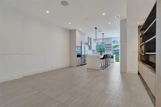 a kitchen with kitchen island a stove a chandelier and a refrigerator