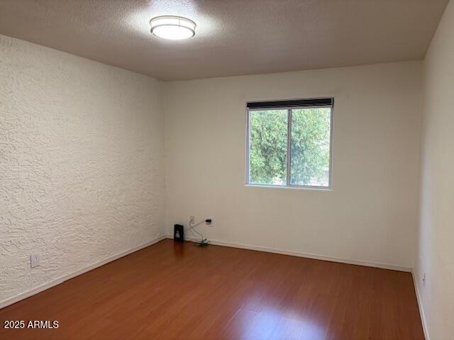 2121 West Royal Palm Road, Unit 2074 Phoenix, AZ 85021 - Photo 13 of 22 an empty room with wooden floor and windows