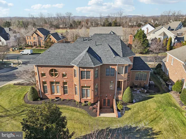 a view of an empty room with wooden floor and a fireplace