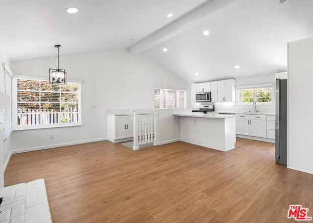 a view of a kitchen with a sink wooden cabinets and appliances
