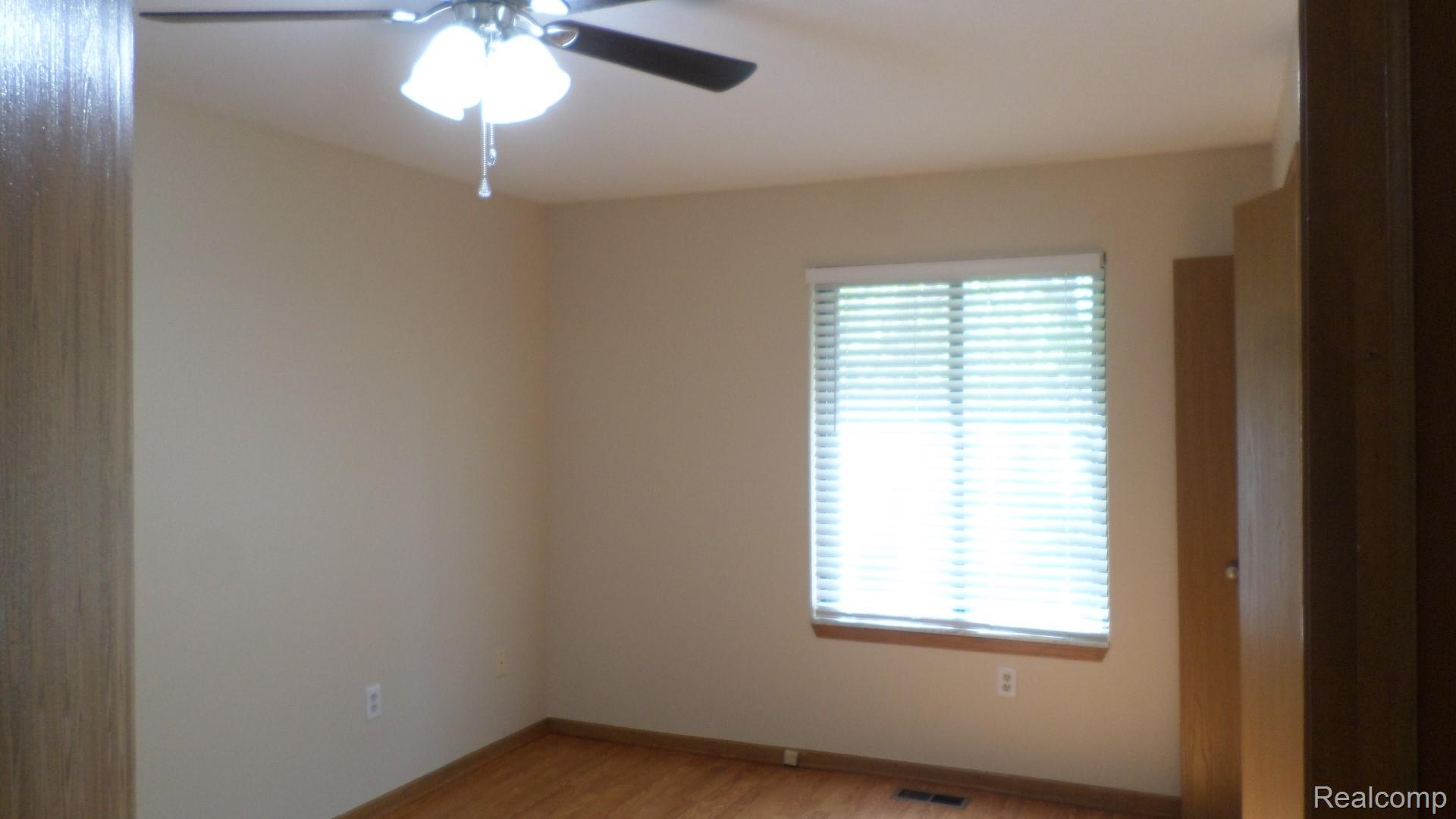 33831 Hooker Road, Unit 6 New Baltimore, MI 48047 - Photo 11 of 34 Spare room featuring ceiling fan and light wood finished floors