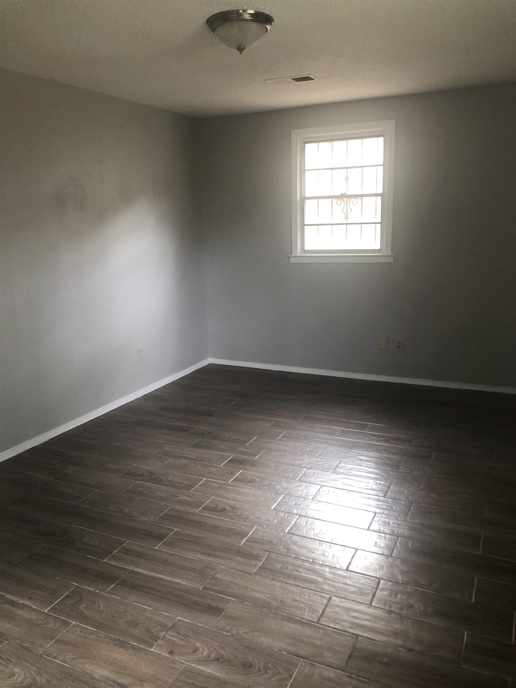 1698 Rayner Street Memphis, TN 38106 - Photo 3 of 8 an empty room with wooden floor and windows