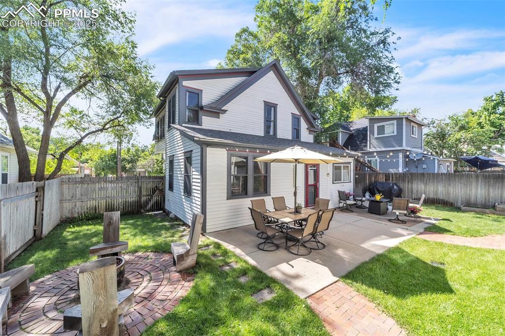 319 South Institute Street Colorado Springs, CO 80903 - Photo 38 of 49 a view of a patio with table and chairs under an umbrella with wooden fence