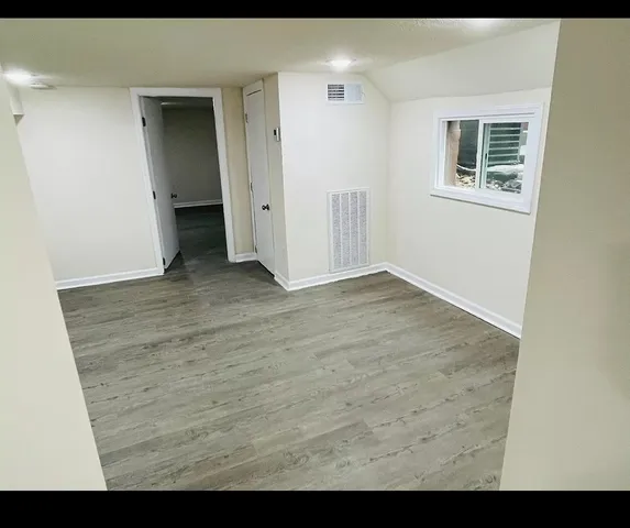 a view of an empty room with closet and a window