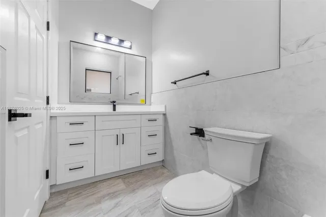 a bathroom with double vanity sink and two mirror
