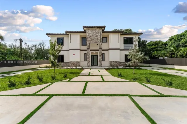 a view of a white house with a yard and plants