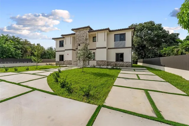 an aerial view of a house with a yard and trees