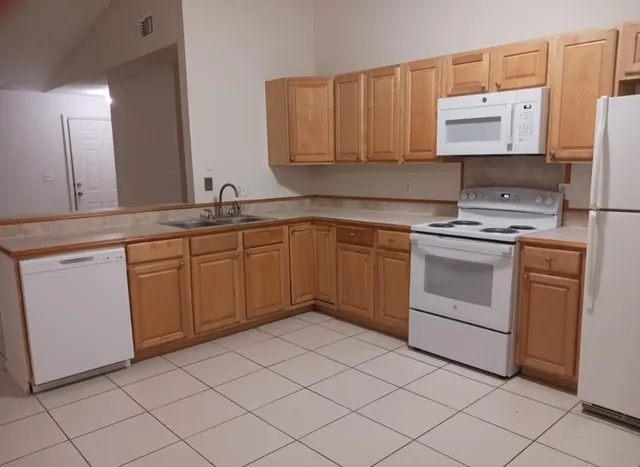 a kitchen with a stove sink and cabinets