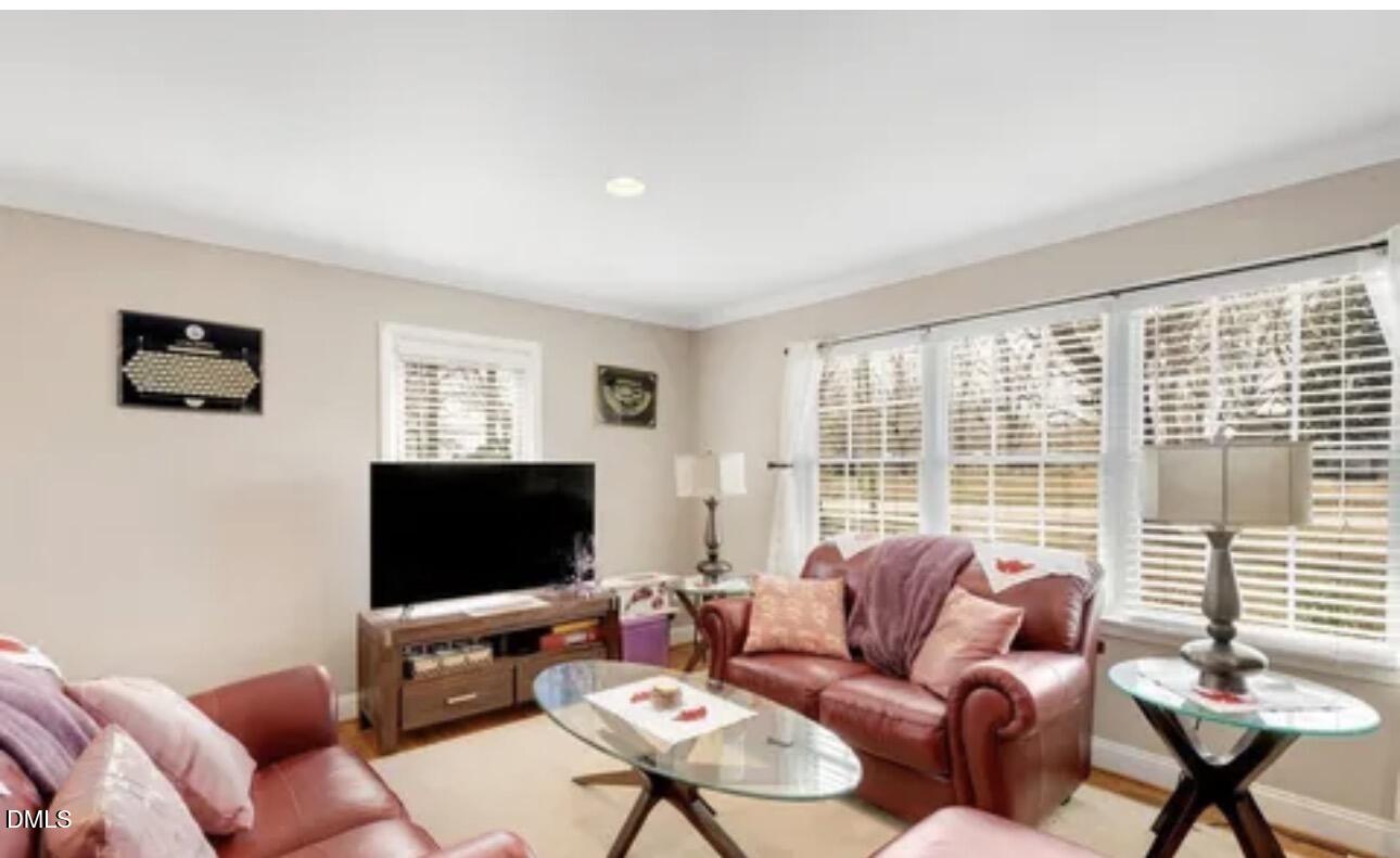 810 Milton Road Durham, NC 27712 - Photo 4 of 21 a living room with furniture a flat screen tv and a large window