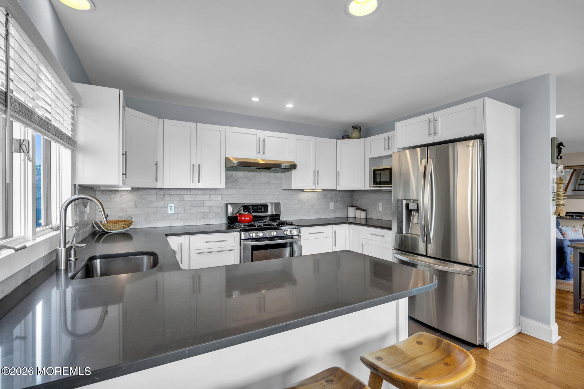 211 Forman Avenue Point Pleasant Beach, NJ 08742 - Photo 19 of 69 a kitchen with stainless steel appliances granite countertop a refrigerator a sink a stove a dining table and chairs with wooden floor