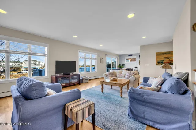 a living room with furniture a wooden floor and a flat screen tv