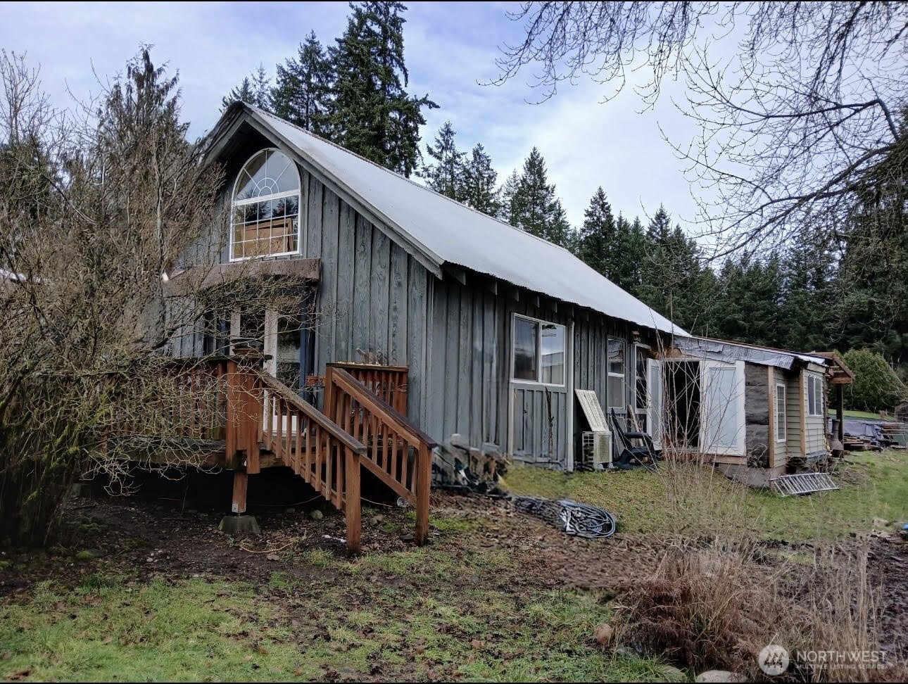 a view of a house with a yard and a large tree