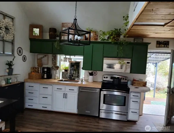 a kitchen with stainless steel appliances kitchen island granite countertop a stove a sink and a microwave
