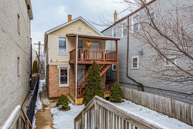 1114 West Cullerton Street, Unit 1 Chicago, IL 60608 - Photo 1 of 10 a view of a house with wooden fence and two windows